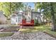 Charming backyard with brick patio, red deck, mature trees, and garden beds at 716 Beddingfield Dr, Knightdale, NC 27545