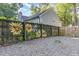 Spacious backyard features a wooden fence with charming sunflower paintings, gravel, and a convenient gate at 716 Beddingfield Dr, Knightdale, NC 27545