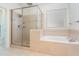 Bathroom featuring a glass enclosed shower and a separate soaking tub near a window at 716 Beddingfield Dr, Knightdale, NC 27545