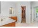 Bright bathroom with double sinks and an open walk-in closet, next to another doorway at 716 Beddingfield Dr, Knightdale, NC 27545