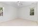 Empty bedroom with neutral carpet, white walls, and bright natural light from the two windows at 716 Beddingfield Dr, Knightdale, NC 27545