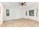 Bright primary bedroom featuring tray ceiling, ceiling fan, carpet and windows offering natural light at 716 Beddingfield Dr, Knightdale, NC 27545