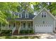 Inviting home with a covered front porch, a yellow front door, and well-maintained landscaping at 716 Beddingfield Dr, Knightdale, NC 27545