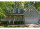 Charming two-story home featuring a welcoming front porch, two car garage, and well-manicured landscaping at 716 Beddingfield Dr, Knightdale, NC 27545