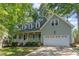 Charming two-story home featuring a welcoming front porch, two car garage, and well-manicured landscaping at 716 Beddingfield Dr, Knightdale, NC 27545