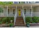 Close-up view of the home's entrance featuring a bright yellow door and brick stairs at 716 Beddingfield Dr, Knightdale, NC 27545