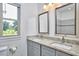 Elegant bathroom vanity with granite counters, double sinks, framed mirrors, and natural light from the window at 931 Ramseur St, Durham, NC 27701