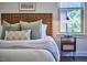 Cozy bedroom with woven headboard, decorative pillows, and natural light at 931 Ramseur St, Durham, NC 27701