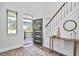 Bright foyer showcasing a staircase, console table, mirror, and a modern front door leading to the porch at 931 Ramseur St, Durham, NC 27701