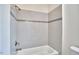 Shower with sleek white tiling, accented with gray stripes, including a bathtub at 931 Ramseur St, Durham, NC 27701