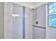 Modern shower with gray and white tiles and brushed metal fixtures, near the window at 931 Ramseur St, Durham, NC 27701