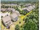 Aerial view showcasing the home's backyard, with a large lawn, deck, and privacy fence at 1020 Regency Cottage Pl, Cary, NC 27518