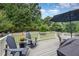 Outdoor deck featuring comfortable seating, a dining table, and a barbecue grill with a lush backyard view at 1020 Regency Cottage Pl, Cary, NC 27518