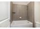 Close-up of a bathtub with tiled walls, a shower head, and a white shower curtain rod at 1020 Regency Cottage Pl, Cary, NC 27518