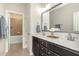 Well-lit bathroom with double sinks, a large mirror, and an open view to the bathtub and shower at 1020 Regency Cottage Pl, Cary, NC 27518