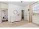 Cozy bedroom showcasing a white dresser, round mirror and lots of natural light from the window at 1020 Regency Cottage Pl, Cary, NC 27518