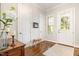 Bright foyer featuring hardwood floors, white trim, and a welcoming front door with sidelight at 1020 Regency Cottage Pl, Cary, NC 27518