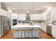 Spacious kitchen features a large center island with seating, quartz countertops, and stainless appliances at 1020 Regency Cottage Pl, Cary, NC 27518