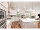 Open-concept kitchen boasts stainless steel appliances, a large island, and seamless flow to the living area at 1020 Regency Cottage Pl, Cary, NC 27518