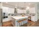Beautiful kitchen with white cabinets, stainless steel appliances, quartz countertops, and a center island at 1020 Regency Cottage Pl, Cary, NC 27518