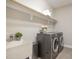 Functional laundry room with modern appliances, a sink, and a shelf for storage at 1020 Regency Cottage Pl, Cary, NC 27518
