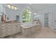Relaxing bathroom with a large tub under a window, double sinks, and lots of counter space at 1028 Harpers Ridge Ct, Wake Forest, NC 27587