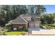 A view of a two-story brick home with a large driveway and a two-car garage surrounded by lush greenery at 1028 Harpers Ridge Ct, Wake Forest, NC 27587