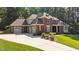 Charming two-story red brick home with a spacious driveway and a three-car garage nestled in a lush green yard at 1028 Harpers Ridge Ct, Wake Forest, NC 27587