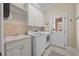 Convenient laundry room featuring washer, dryer, sink, and storage cabinets at 1028 Harpers Ridge Ct, Wake Forest, NC 27587