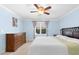 Bedroom with a large bed, blue walls, ceiling fan, dresser and natural light at 10570 Evergreen Spring Pl, Raleigh, NC 27614