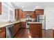 Well-equipped kitchen featuring stainless steel appliances, granite countertops, and wood cabinetry at 10570 Evergreen Spring Pl, Raleigh, NC 27614