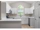 Modern kitchen featuring white cabinets, stainless steel appliances, and quartz countertops at 108 Ellsworth Pl, Cary, NC 27511
