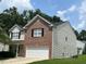 Two-story home with a brick facade and vinyl siding, showcasing its well-maintained exterior and front lawn at 1100 Birkdale Dr, Mebane, NC 27302