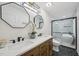 Bathroom featuring dual sinks, decorative mirrors, and a glass-enclosed shower at 1104 Suterland Rd, Cary, NC 27511