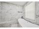 Bathroom featuring a luxurious soaking tub and marble-style walls at 1104 Suterland Rd, Cary, NC 27511