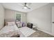 Cozy bedroom features neutral walls, wood-look floors, ceiling fan, and a bright window at 1104 Suterland Rd, Cary, NC 27511