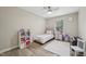 Well-lit bedroom features a single bed, ceiling fan, and plenty of shelf space at 1104 Suterland Rd, Cary, NC 27511