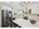 Updated kitchen features white cabinets, stainless appliances, and a large center island with bar stool seating at 1104 Suterland Rd, Cary, NC 27511