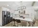 Bright kitchen with white cabinets, a large island, stainless steel appliances, and modern light fixtures at 1104 Suterland Rd, Cary, NC 27511