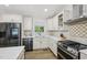 A stylish kitchen showcases white cabinets, quartz countertops, stainless steel appliances, and modern fixtures at 1104 Suterland Rd, Cary, NC 27511