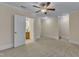 Bedroom featuring a ceiling fan, neutral carpeting, trim, and walls, as well as a bathroom and stairs at 117 Finsbury St, Durham, NC 27703
