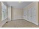 Bright bedroom featuring neutral carpeting, trim, and walls, as well as a window and closets at 117 Finsbury St, Durham, NC 27703