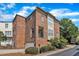 Brick townhouse featuring a private balcony and a one-car garage, plus lush landscaping at 117 Finsbury St, Durham, NC 27703
