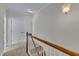 Upstairs hallway with carpet, white wood railing, and a double door closet at 117 Finsbury St, Durham, NC 27703