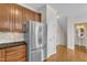 Kitchen featuring stainless steel appliances, wooden cabinets, and an adjacent powder room at 117 Finsbury St, Durham, NC 27703