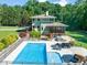 Aerial view of the home's backyard with the pool, spa, outdoor kitchen and entertainment spaces at 1209 Ravens Point Cir, Raleigh, NC 27614