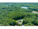 Aerial view of a luxurious property surrounded by verdant forest and a tranquil lake nearby at 1209 Ravens Point Cir, Raleigh, NC 27614