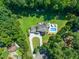 Overhead view of a home with an in-ground pool, lush landscaping, and a circular driveway at 1209 Ravens Point Cir, Raleigh, NC 27614