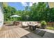 The back deck features an outdoor kitchen, dining and lounging area overlooking a private backyard at 1209 Ravens Point Cir, Raleigh, NC 27614