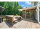A back deck features outdoor seating and a grill near a screened in porch, perfect for entertaining at 1209 Ravens Point Cir, Raleigh, NC 27614